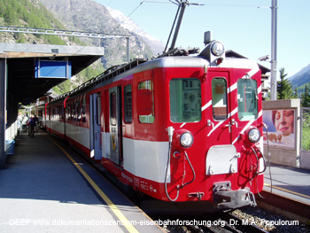 Umsteigen in den Zug der Brig-Visp-Zermatt-Bahn in Tsch, Zug noch in alter Farbgebung vor Fusionierung; Gornergratbahn - DEEF Dr. Michael Populorum